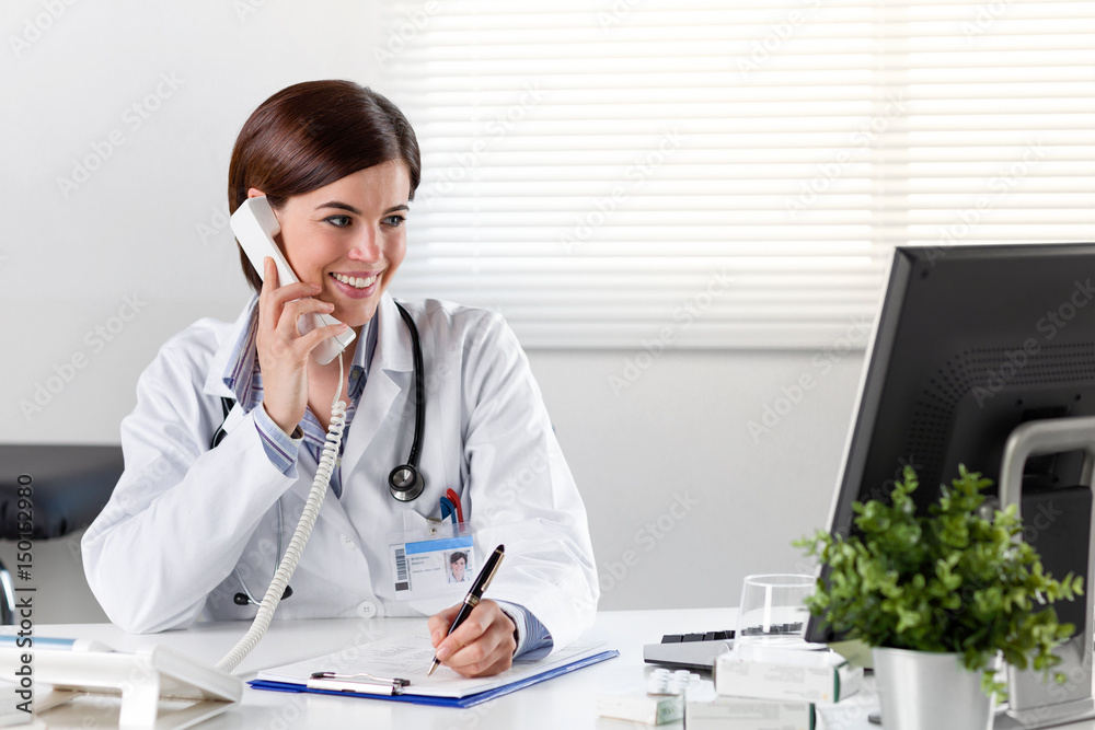 Female doctor at desk with telephone Female doctor at desk with telephone