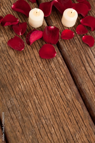 Foto Wax candles surrounded with rose petals