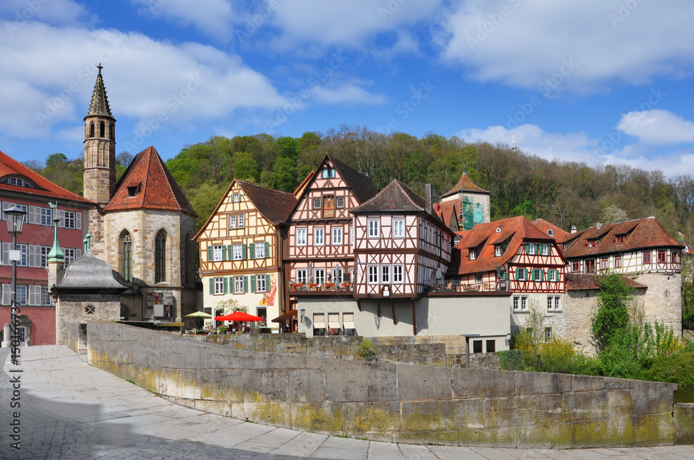 Quay Schwabisch Hall with a Gothic church of St. John and half-timbered houses at sunny day. Baden-Wurttemberg, Germany.