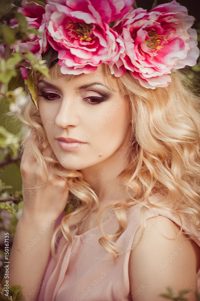 A young girl in floral wreath in nature