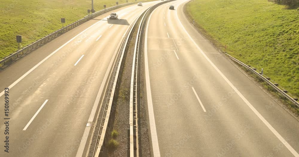 cars and trucks driving on a busy highway at sunset