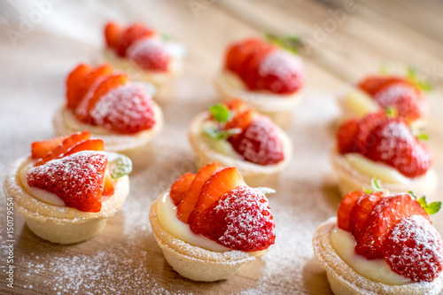 mini strawberry tarts on wood background