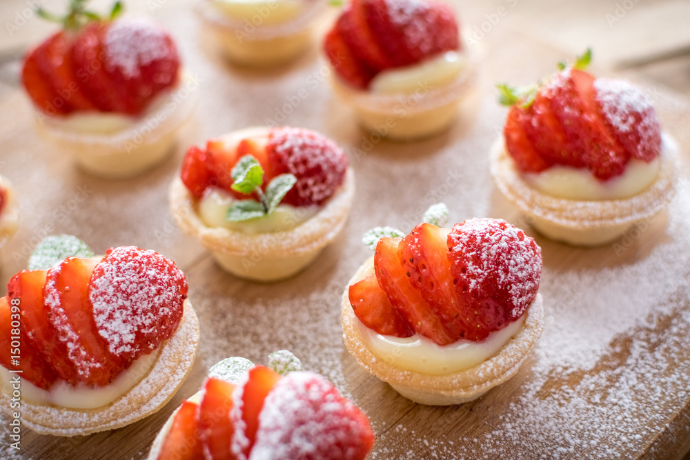 Fototapeta premium mini strawberry tarts on wood background