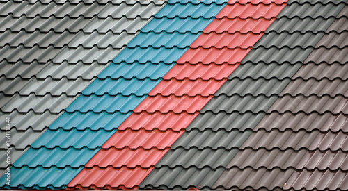 Architectural background. Texture of a metal roof tiles of black, blue and red colors.