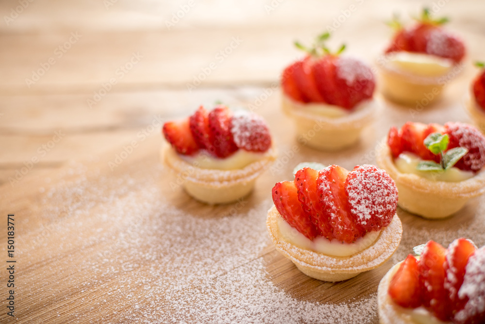 mini strawberry tarts on wood background