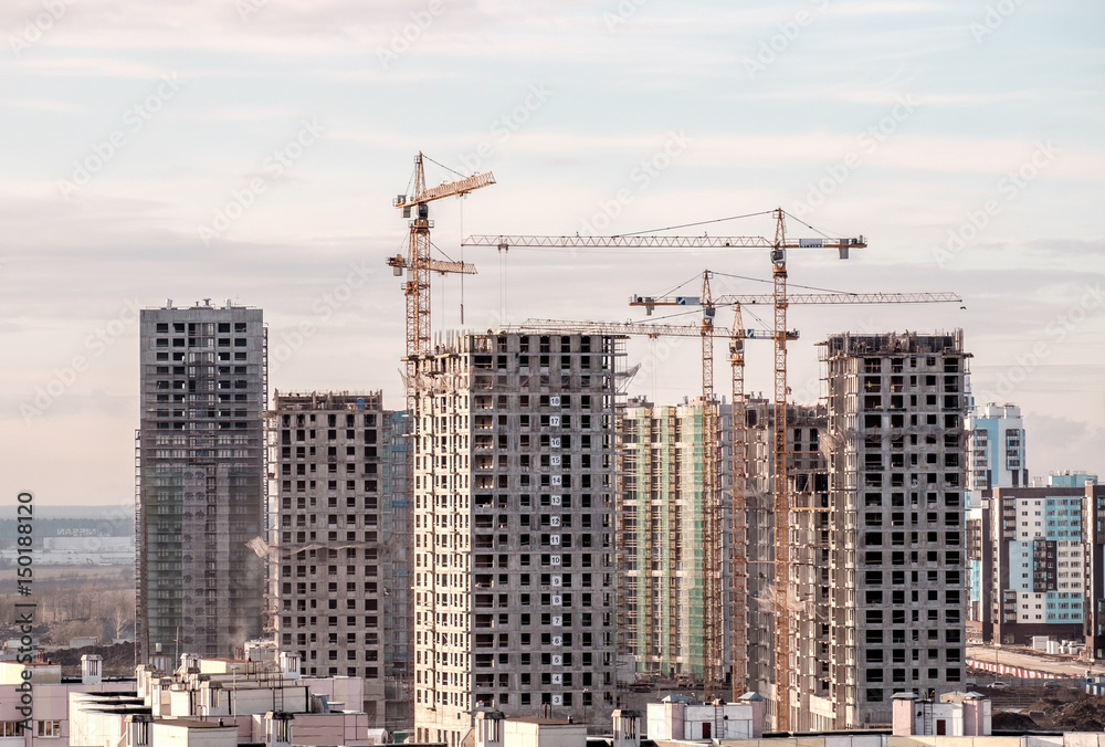 Fototapeta premium Building crane and buildings under construction