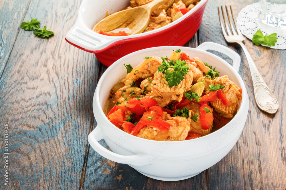Healthy low-calorie dish, turkey fillet stewed with vegetables, in white bowl on the wooden rustic table. Healthy low-calorie dish, turkey fillet stewed with vegetables, in white bowl on the wooden rustic table.