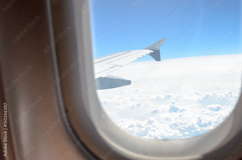 High above the clouds: View through the window of an aircraft High above the clouds: View through the window of an aircraft