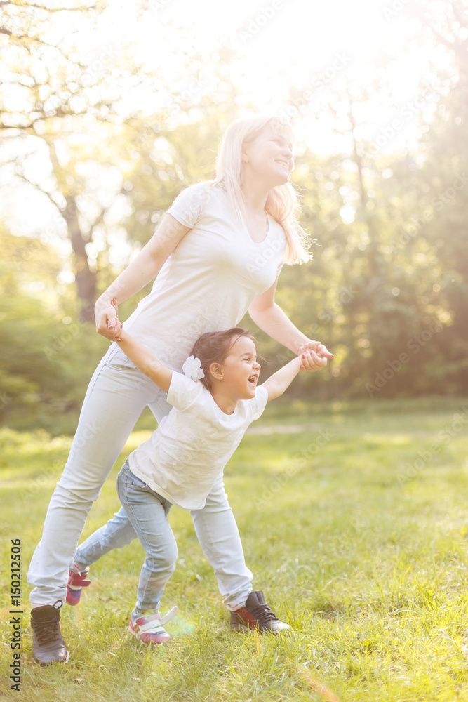 Fototapeta premium sporty mother and daughter. woman and child training in the park. outdoor sports. healthy sport lifestyle. fitness, yoga