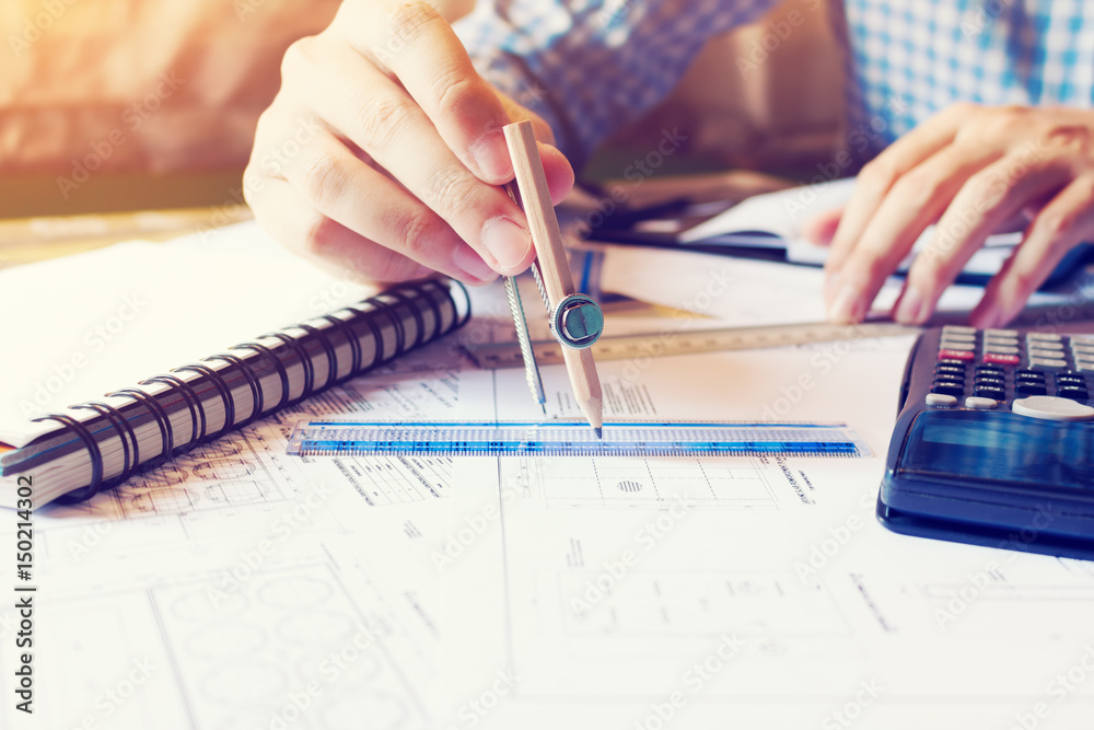 Architect man drawing geometric shape on blueprint at office table.