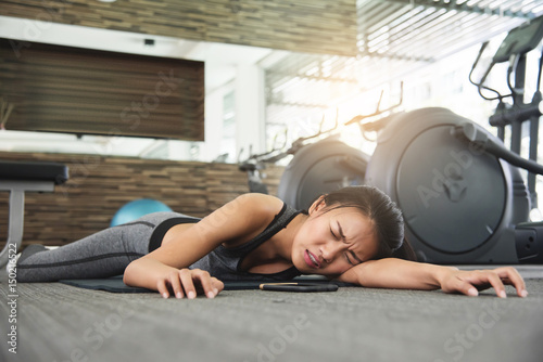 Asian woman fainting while workout at the gym.