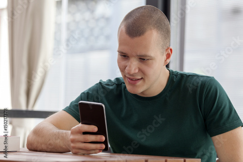 young man in a cafe mobile telephone