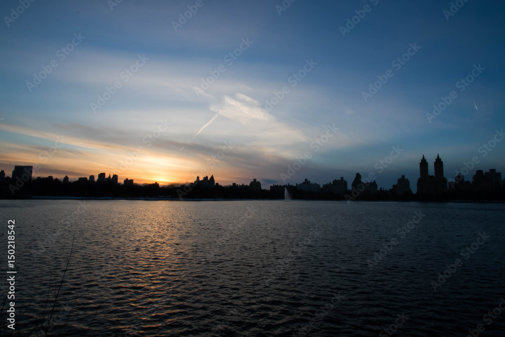 Blurred sunset over buildings and lake at Central Park