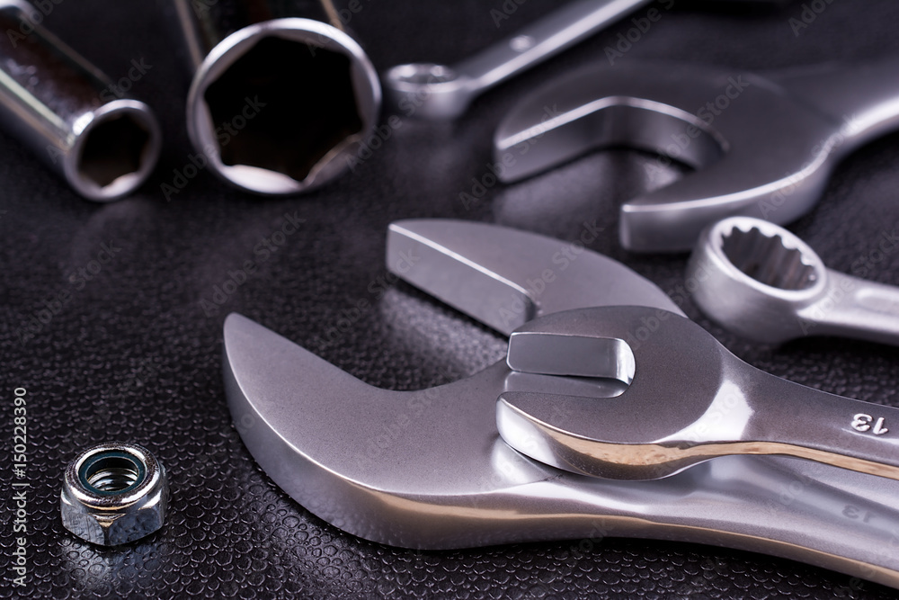 Fototapeta premium Spanners of various sizes, on dark abstract background.