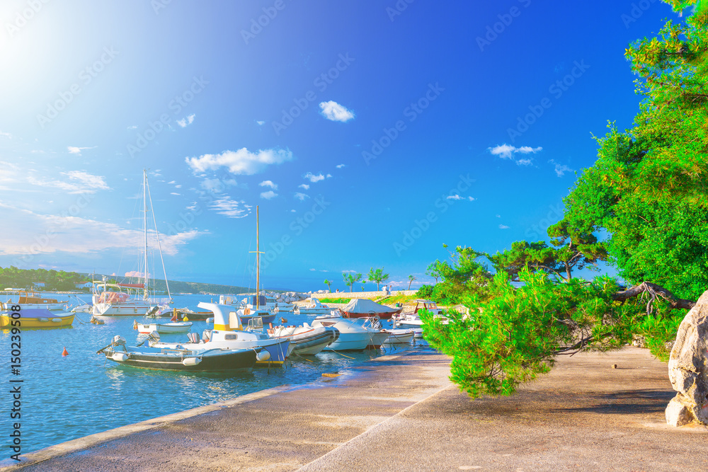 Fototapeta premium Wonderful romantic summer evening landscape panorama coastline Adriatic sea. Boats and yachts in harbor at cristal clear azure water. Old town of Krk on the island of Krk. Croatia. Europe.