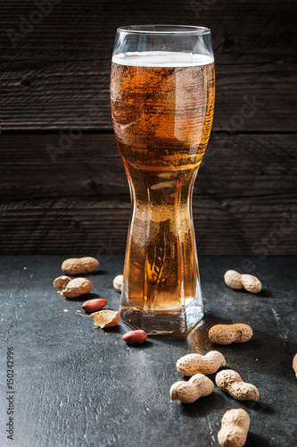 Beer and peanuts on the wooden background photo