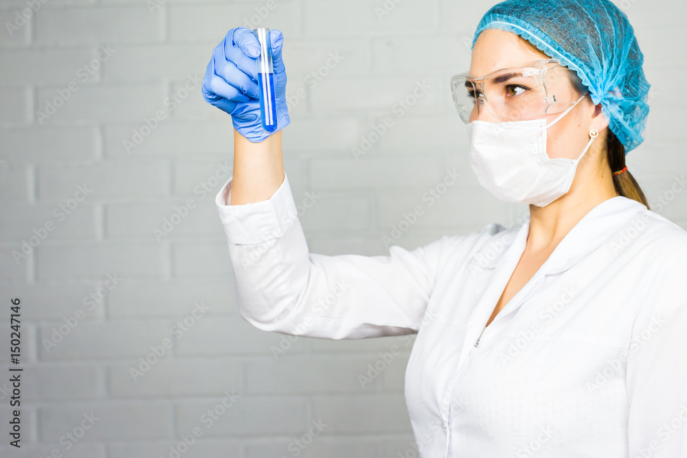 Naklejka premium Mask and goggles protected life science researcher observing. Focus on scientist's eye. Health care and biotechnology concept.