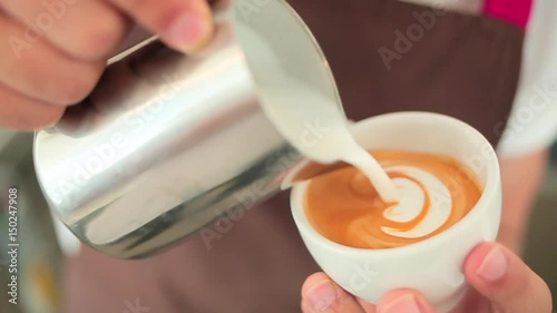 The barista makes a drawing on coffee.