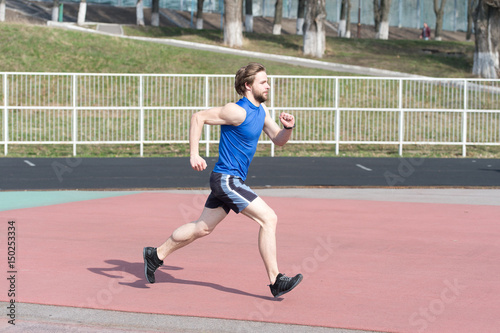 running man in sport arena sunny outdoor