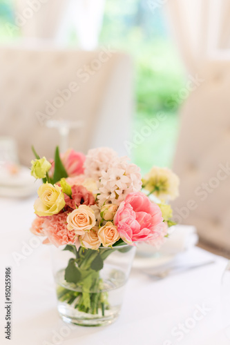 Flower table decorations for holidays and wedding dinner. Table set for holiday, event, party or wedding reception in outdoor restaurant.