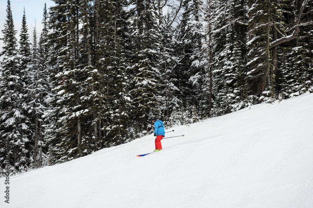 Skier skiing on snow covered mountain slope Skier skiing on snow covered mountain slope