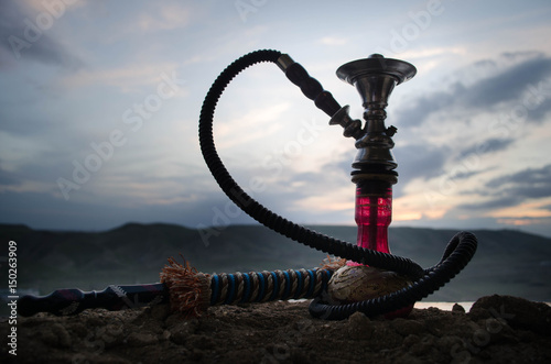 Photography Hookah, traditional arabic waterpipe, direct sunset light, outdoor photo