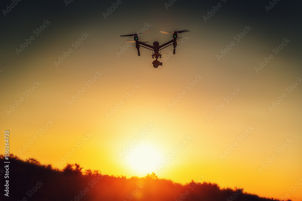 Drone flying above the field at sunset