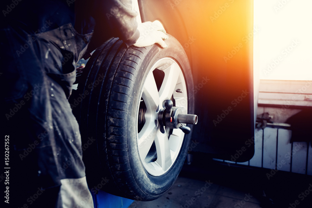 Foto de repairman balances the wheel and installs the tubeless tire of