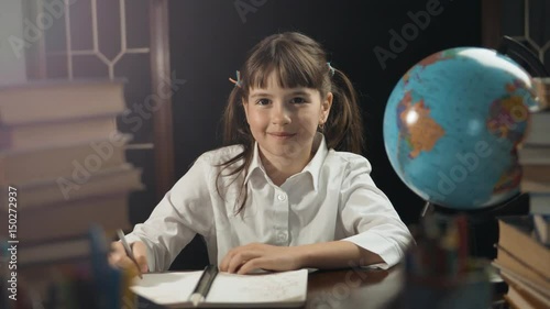Eight years school girl use globe and notebook, studying place with book, education concept, 30FPS