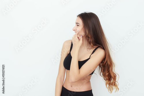 Beautiful girl in black top on white background shows emotion