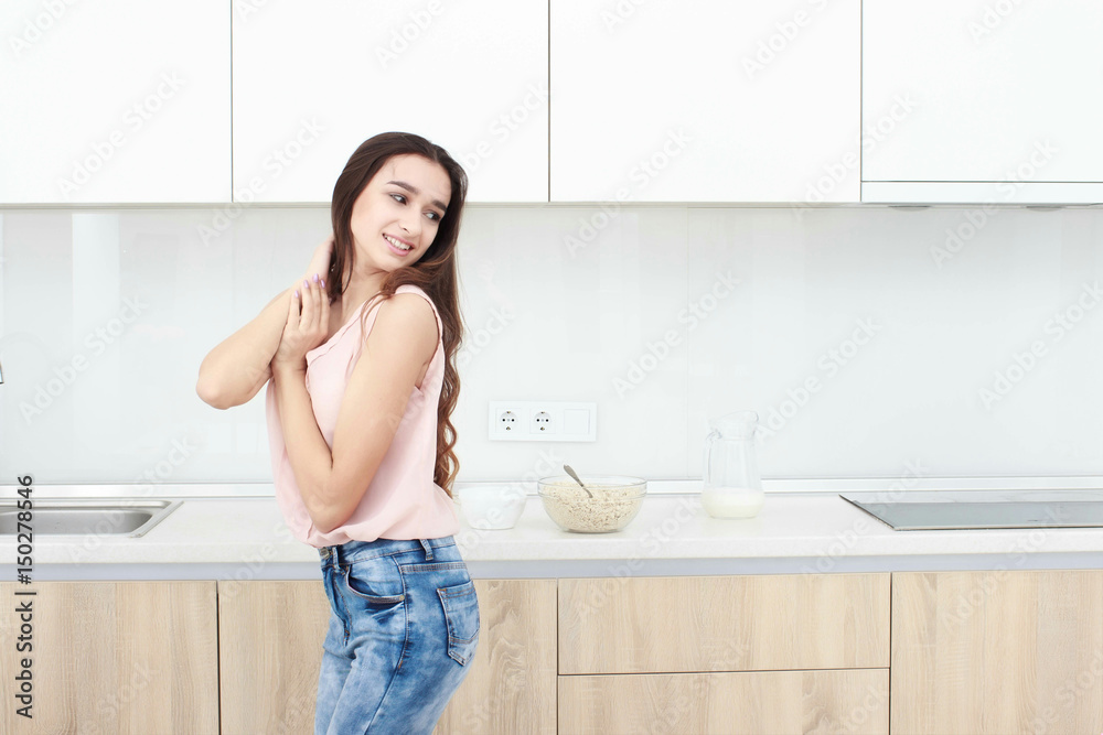 Serious attitude. Young smiling lady standing in a kitchen. Serious attitude. Young smiling lady standing in a kitchen.