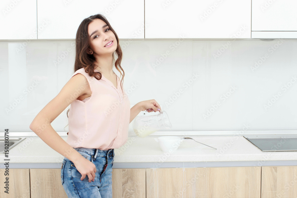 Woman pouring milk on plate with cereal muslin at kitchen Woman pouring milk on plate with cereal muslin at kitchen