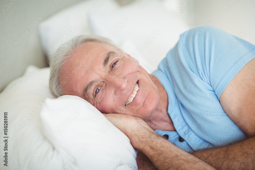 Portrait of happy senior man lying on bed Portrait of happy senior man lying on bed
