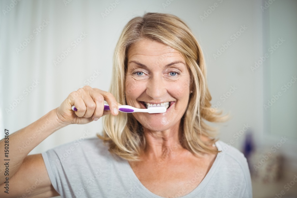 Portrait of senior woman brushing her teeth in bathroom Portrait of senior woman brushing her teeth in bathroom