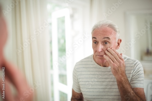 Senior man looking at mirror