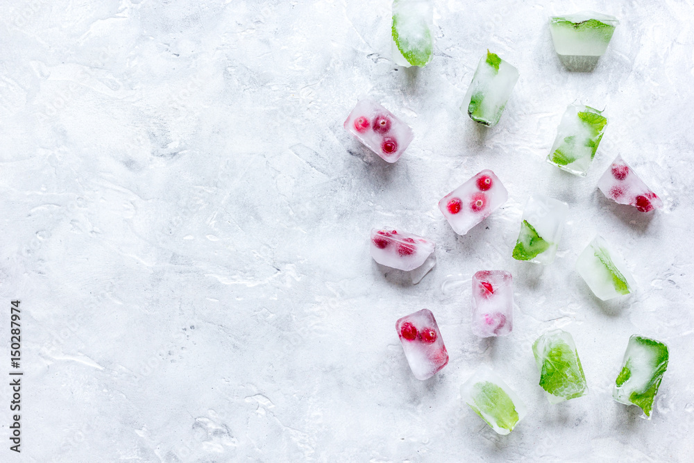 Ice cubes with berries and mint stone background top view mock up Ice cubes with berries and mint stone background top view mock up