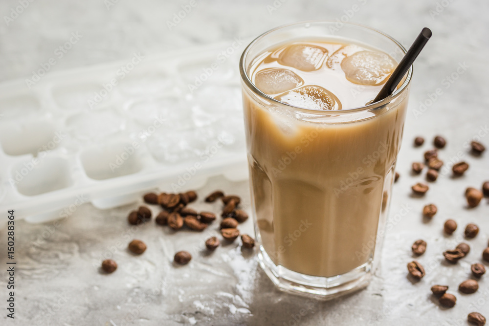 coffee break with cold iced latte and beans on stone table background coffee break with cold iced latte and beans on stone table background