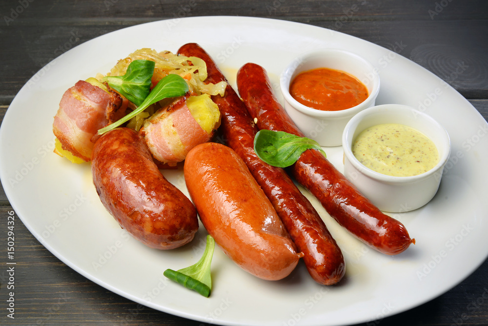 Grilled sausage with potato and sauce on a plate Grilled sausage with potato and sauce on a plate