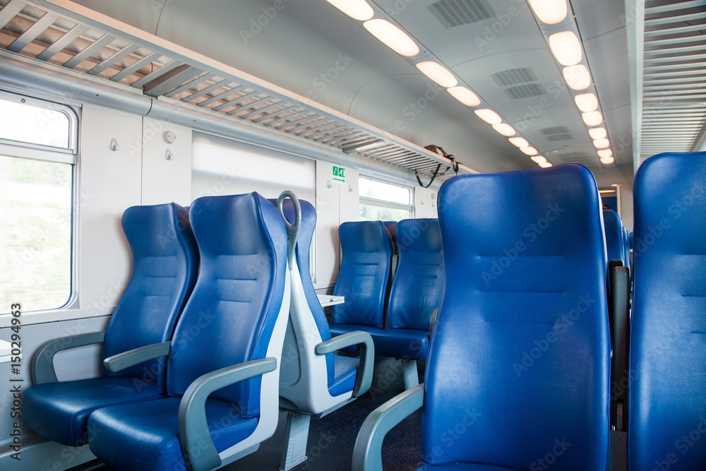 interior of a train wagon with empty seats interior of a train wagon with empty seats