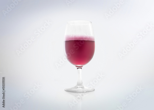 Glass of a red drink with bubbles (rosé champagnes & sparkling strawberry / cherry). Isolated on white background.