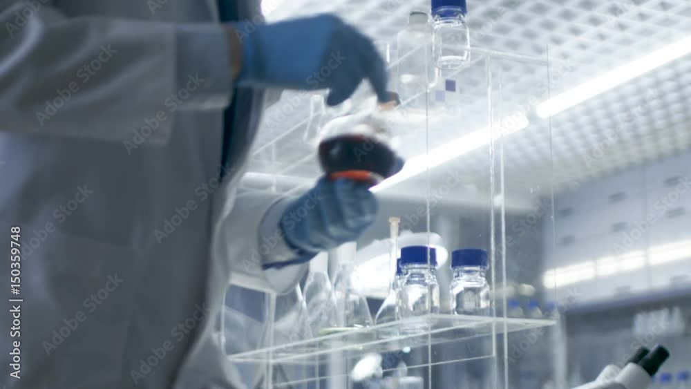 In High-End Laboratory Research Scientist Picks up Beaker of the Shelf and Examines Content. Shot on RED EPIC-W 8K Helium Cinema Camera.