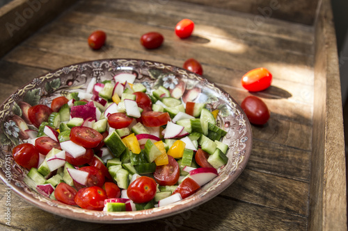 bowl with vegetable spring cut salad, tomato, pepper, radish, cucumber © Olga Kulakova