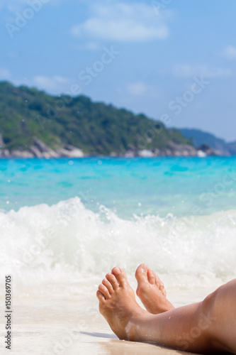 Female legs on the backdrop of the Andaman sea. Holidays, vacation