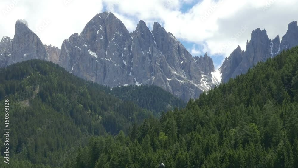 Zooming out view of Geisler Group Dolomites (Geislergruppe, Geislerspitzen, Le Odle) and St Johann in Ranui chapel, in Villnoss Valley (Villnosstal, Val di Funes), Bolzano, Northern Italy. Zooming out view of Geisler Group Dolomites (Geislergruppe, Geislerspitzen, Le Odle) and St Johann in Ranui chapel, in Villnoss Valley (Villnosstal, Val di Funes), Bolzano, Northern Italy.