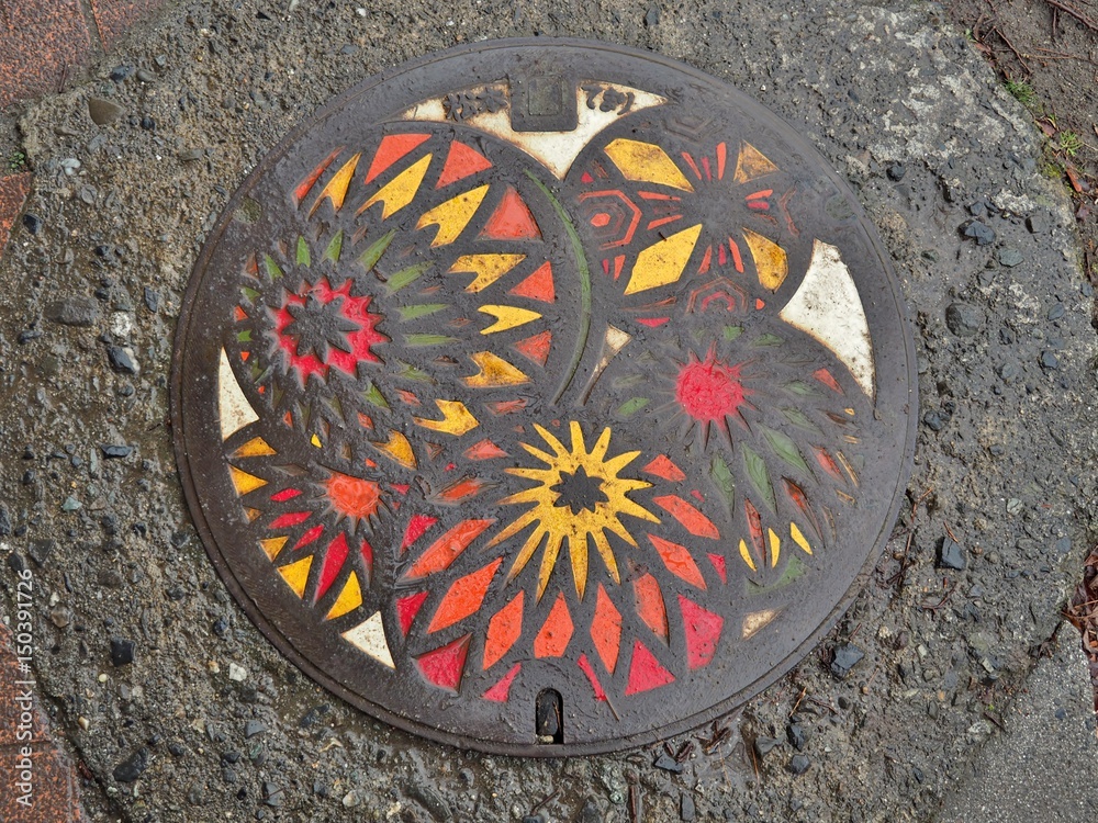 A manhole cover of Matsumoto city, Nagano Prefecture, Japan. Temari balls engraved on a manhole cover. Matsumoto-temari are folkcraft balls decorated with yarn.