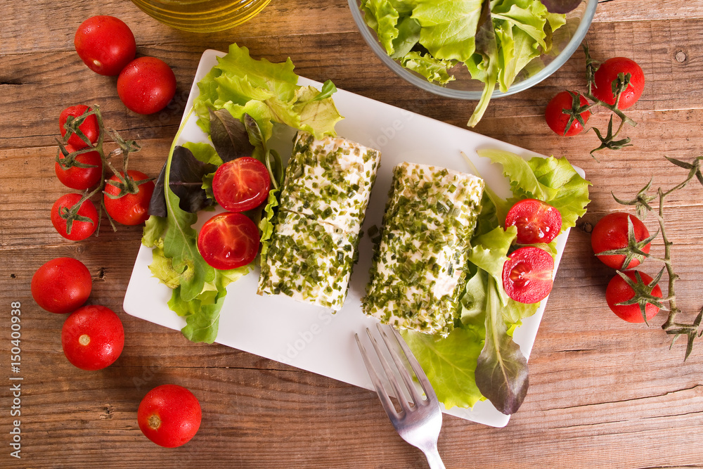 Goat cheese with salad and cherry tomatoes. Goat cheese with salad and cherry tomatoes.