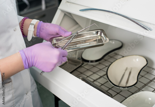 Foto Dentist with gloved hands is working with dental equipment in dental office