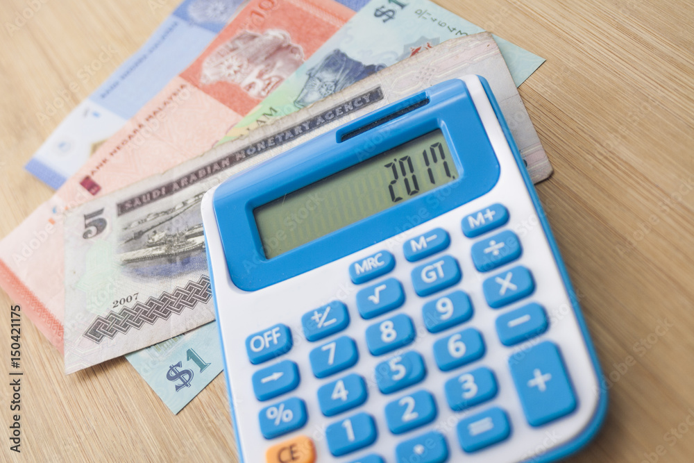 Selective focus, Currency note and calculator over the wooden board Selective focus, Currency note and calculator over the wooden board