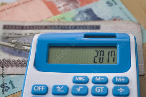 Selective focus, Currency note and calculator over the wooden board