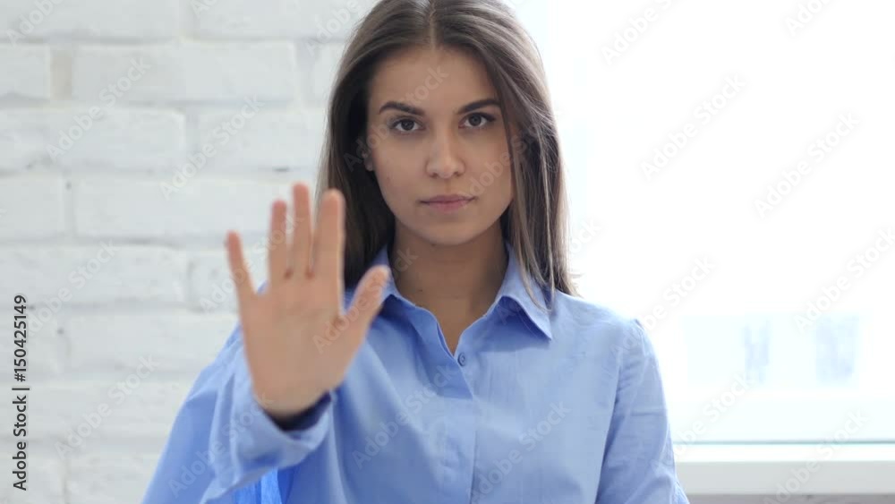 Portrait of Beautiful Young Woman Gesturing Stop Sign with Hand Portrait of Beautiful Young Woman Gesturing Stop Sign with Hand